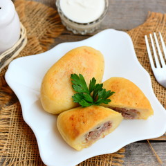 Fried potato cutlets stuffed with meat on a white plate and on an old wooden background. How to make mince stuffed potato cutlets. Closeup