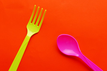 Colorful plastic spoon isolated on orange background.