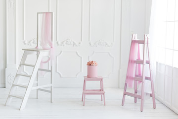 Simple white interior, pink ladder decor and flowers in the box.