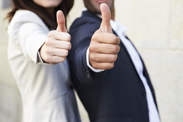 Business colleagues with thumbs up together, close up