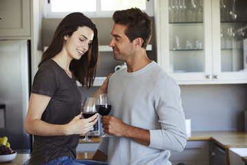 Romantic couple with wine in kitchen