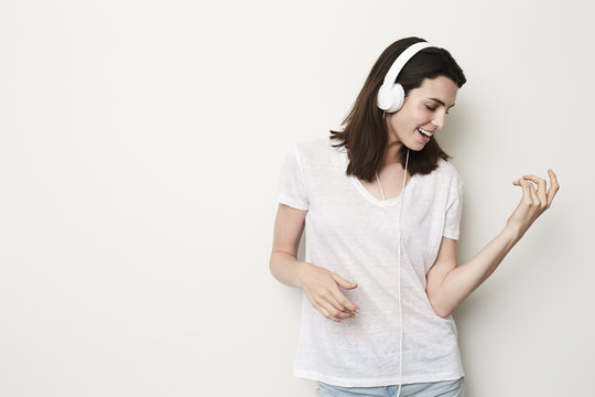 Air Guitar Girl Playing To Headphones In Studio