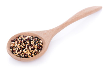 Real quinoa seeds in a wooden spoon isolated on white