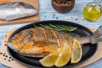Grilled dorado in pan on wooden Background