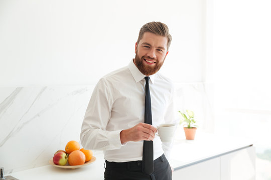 Smiling bearded business man drinking coffee