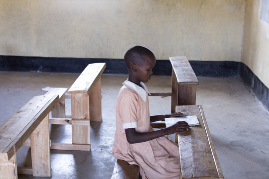 School girl studying alone in classroom. Kenya, Africa.