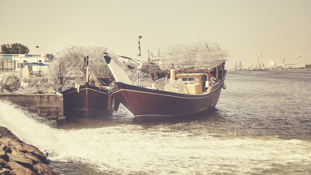 Fishing boats in Ajman harbor, color toning applied, United Arab Emirates.