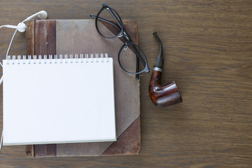 Notebook mock up for artwork with headphones and glasses. Top view. Place for text.