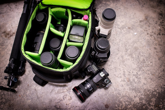 Photographer pack his camera and lenses to bagpack.