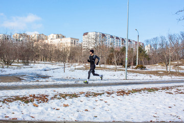 young runner training outdoor in winter park 