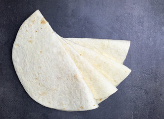 Tortilla wraps on black background. Top view.