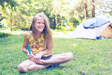 Joyful girl teenager sits in a forest glade