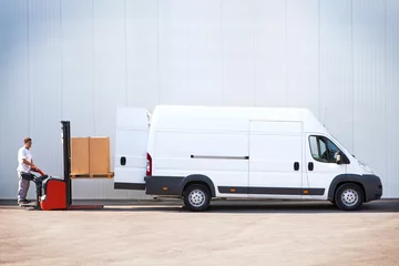 Foto op Plexiglas Courier is loading the van with parcels. © BigBlueStudio