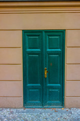 green door in a brown facade