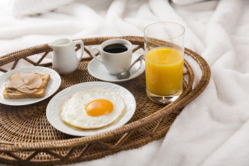 Breakfast Tray in Bed, Lifestyle / Tray with coffee, juice, toast, peanut butter and fried egg in bed