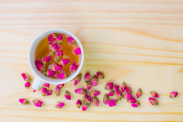 Cup of rose tea on wooden background,top view