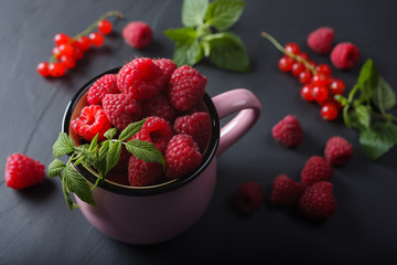 Raspberry in pink mug on stone plate