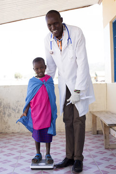 Doctor examining young girl from Maasai tribe. Kenya, Africa