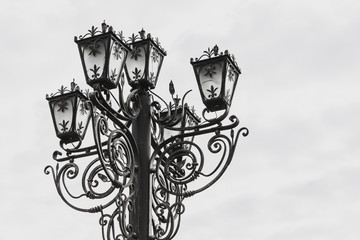 Fototapeta na wymiar Old street lamp. A forged street lamp on a white background.