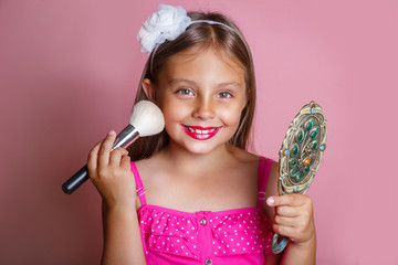 Adorable funny little girl making makeup with mother cosmetics
