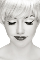 Black and white portrait of young beautiful smiling blond woman with cat eyes make-up