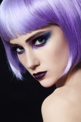 Young beautiful woman with colorful fancy make-up and violet wig
