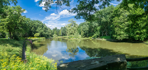 Panorama of a public park in the city. Sunny picture with trees and a lake. Luisenhain, Bamberg.