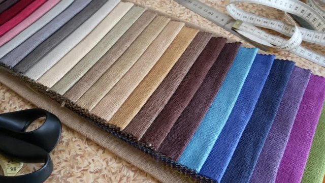 Tissue Samples Stitched Upholstered Furniture On Table At Tailor's WorkShop. Textiles Textures Fabric Swatches. Choice of Fabrics for Upholstery Or Clothing