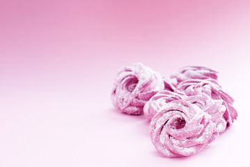 delicate pink marshmallow in powdered sugar, on a pink background