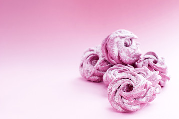 delicate pink marshmallow in powdered sugar, on a pink background