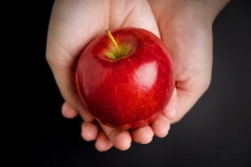 A red apple holding in hand
