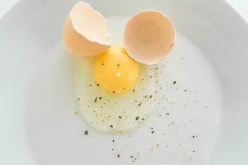 Raw broken eggs with seasoning