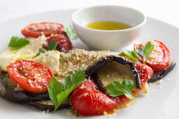 roasted vegetables with olive oil, lemon juice, green herbs, and garlic dressing sprinkled with cheese and decorated with parsley leafs