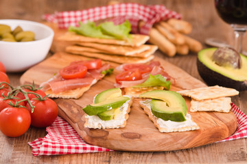 Crackers with ham and avocado. 