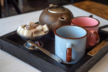 Teaset with two metal cups, sugar tongs and kettle