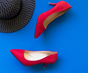 Fashion woman accessories set. Trendy fashion red shoes heels, stylish big hat. blue background.  Lifestyle Concept.