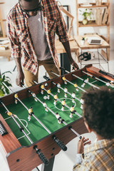 father and son playing playing foosball