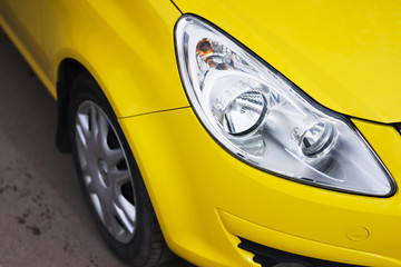 Closeup headlights of modern sport yellow car. Car exterior details