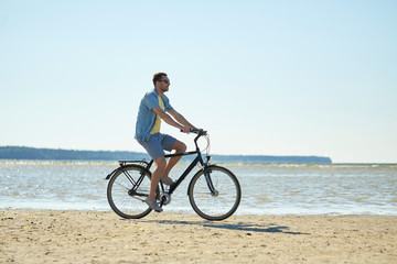 Fototapeta premium happy man riding bicycle along summer beach