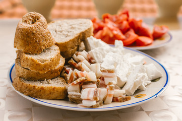Cold smoked bacon with cheese and bread on plate
