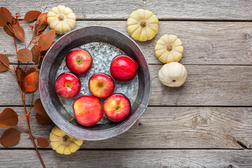 Metal basin with apples in water. Autumn harvest background