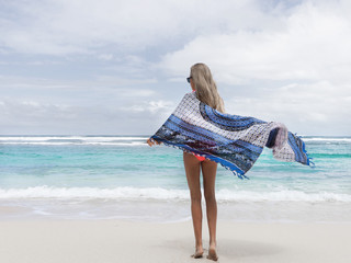 girl with long hair walks along the beach in the evening