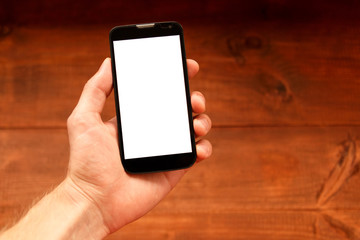 Close up of a man holding smartphone with blank screen mobile. Graphic display montage. Wooden background