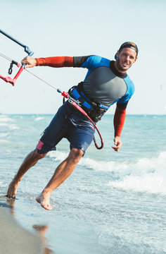 Portrait of handsome man kitesurfer in the beach.
