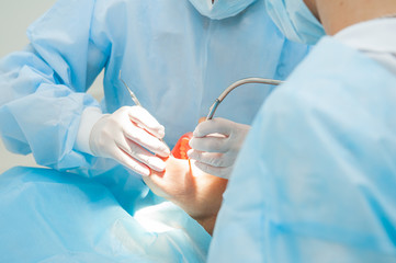 Close up dental surgery process - Implantation. Dentist surgeon with assistant in modern clinic. Stomatology and health care concept. selective focus. Space for text