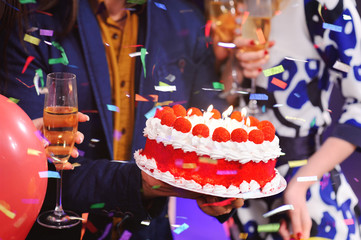 birthday cake with candles close up on the background of the cheerful company of my best friends. party, birthday, holiday