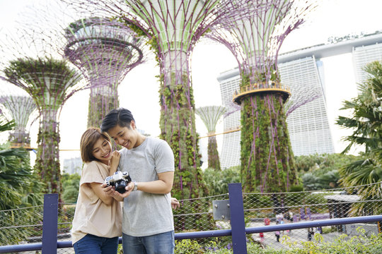 Young couple checking out the images they took at Gardens by the Bay