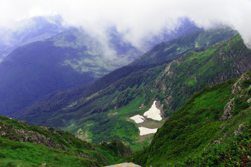 Naklejka premium The tops of high mountains enveloped in a thick fog.
