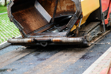 Carrying out repair works: asphalt roller stacking and pressing hot lay of asphalt. Machine repairing road