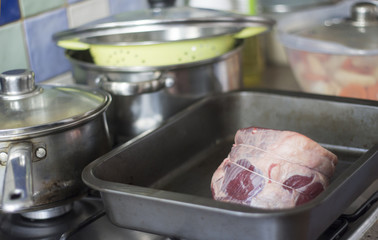 Uncooked beef joint tied up with string in an oven tray